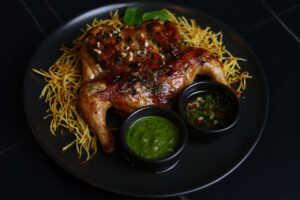 Курча тапака на сіні з картоплі пай з соусом із руколи та олією чилі (за 100г)